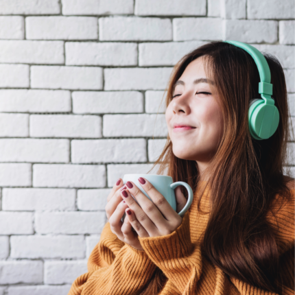 Should Christians Listen to Secular Music blog. This blog was written in conjunction with the UNignorant Podcast episode. The image is a photo of a female listening to music as she enjoys a cup of coffee.