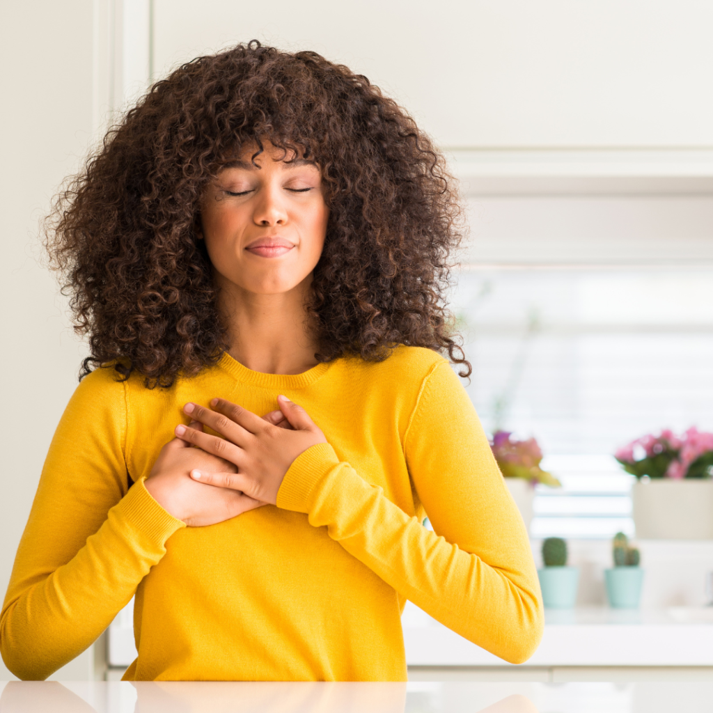 Being Discouraged doesn't mean the end of your journey. You can face these tough times with faith and hope. The image is of a woman placing her hands on her heart as a sign of gratitude.