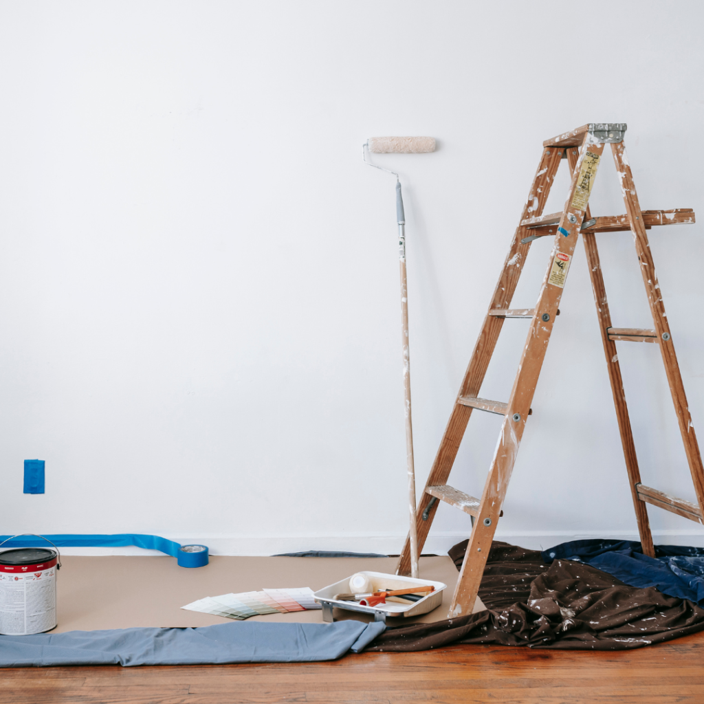 Walking under a ladder as a common superstition. The image is of a paint ladder next to a white wall.